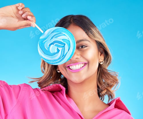 Preview: Woman, lollipop eye and studio portrait for eating, sweets and comic smile with food by blue backgr