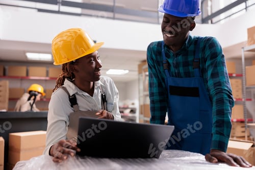 Preview: Smiling logistic department managers analyzing distribution report on laptop