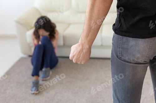 Preview: Victim, domestic violence and abuse concept - man threatening with fist to crying woman on floor