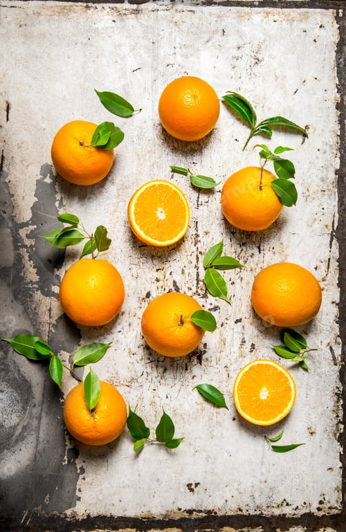 Preview: Fresh oranges with leaves. On rustic background.