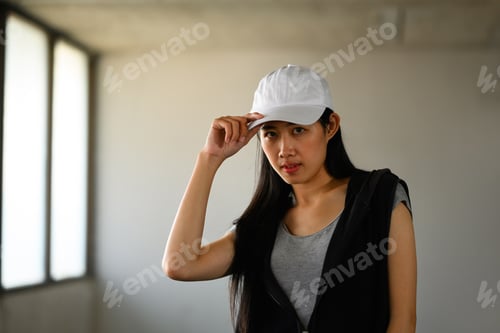 Preview: Portrait of hip hop dancer in cap posing and looking at camera.
