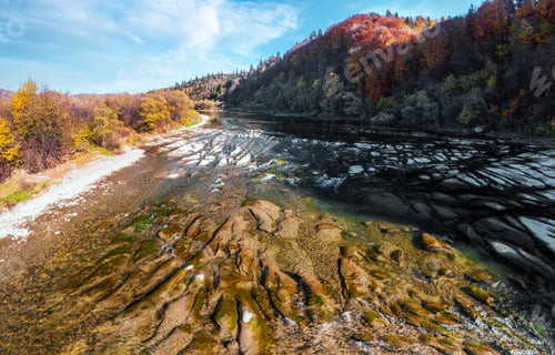Preview: Shallow mountain river at foothill with terracotta forests