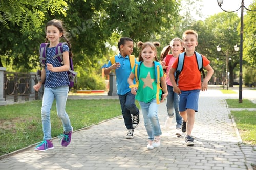 Preview: Cute little children with backpacks running outdoors. Elementary school