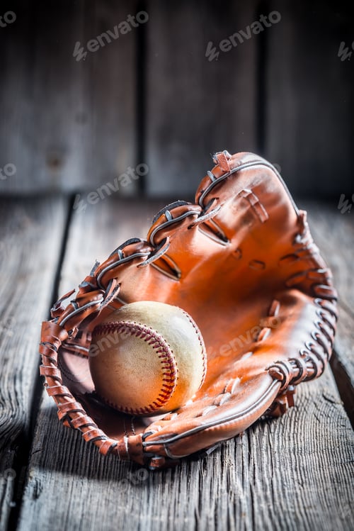 Preview: Old baseball glove and ball on old wooden table