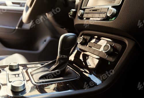 Preview: Close up view of car interior with gear shift and control panel in bright sunlight
