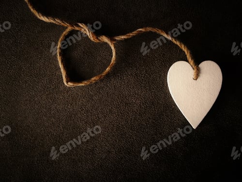 Preview: White heart with rope on brown background. Concept of love and Valentines Day.