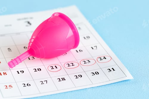 Preview: Calendar page and menstrual cup close up