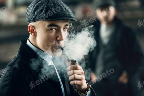 Preview: Stylish man in retro outfit, smoking wooden pipe