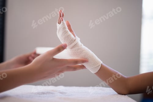 Preview: Close-up of female therapist wrapping bandage on hand