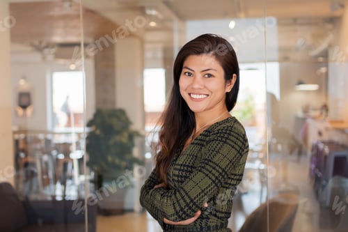 Preview: Smiling Asian worker with arms crossed in office