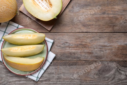 Preview: Pieces of delicious honeydew melon on wooden table, flat lay. Space for text