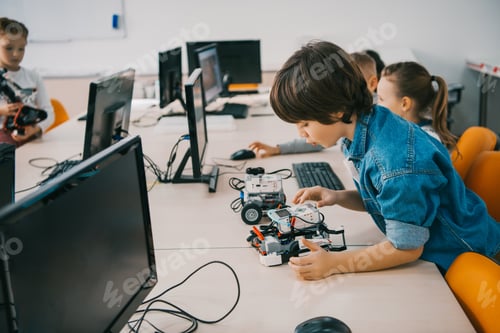 Preview: concentrated teen child constructing robot at class, stem education concept