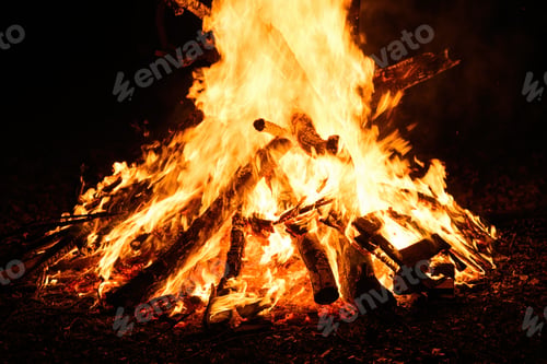 Preview: Bonfire burning at night, bright orange flames of fire, selective focus