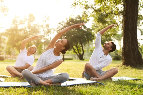 Preview: People practicing yoga in park at morning