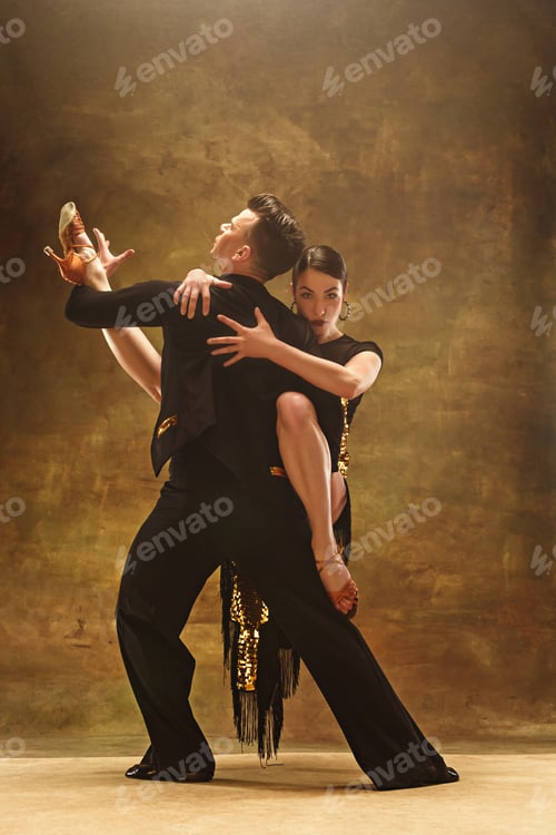 Preview: Dance ballroom couple in gold dress dancing on studio background.