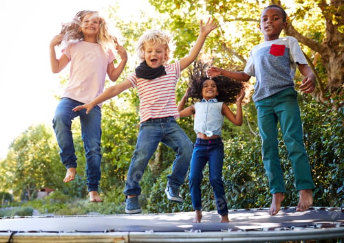 Preview: Four kids having fun together on a trampoline in the garden