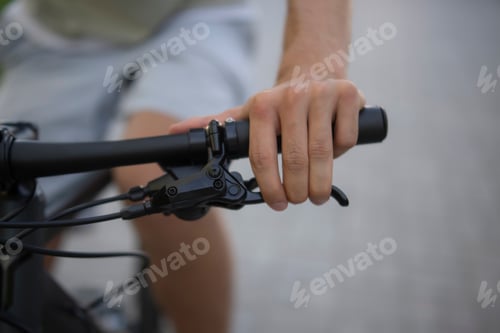 Preview: a hand grips the handlebars of a bicycle with hydraulic brakes