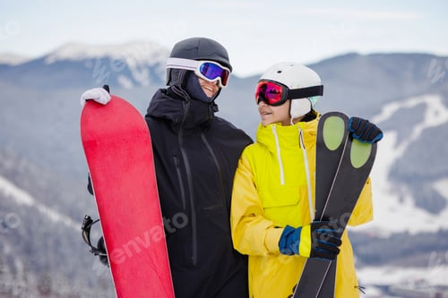 Vorschau: Glückliche Freunde mit Snowboard und Skiern im Wintersportort