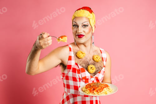 Preview: Smiling Drag Queen Enjoys Spaghetti With Tomato Sauce Against a Pink Backdrop