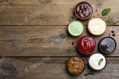 Preview: Many different sauces on wooden table, flat lay. Space for text