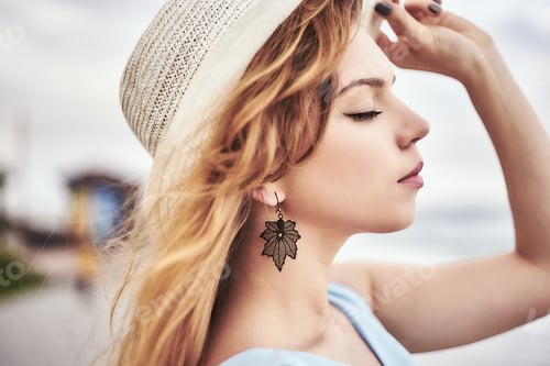Preview: Young woman wearing hat, eyes closed