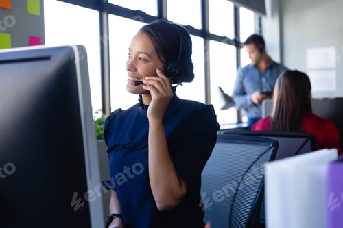 Preview: African American woman working with headset phone in office