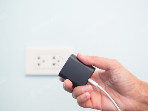 Preview: Finger Plugging a Charger Mobile on Green wall background with free space