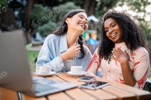 Preview: Two Happy Laughing Young Women Using Laptop In Cafe Outdoors