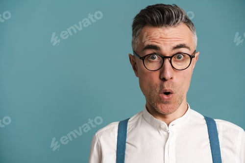 Preview: Shocked grey-haired man in eyeglasses expressing surprise on camera