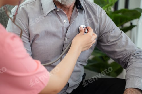 Preview: Nurse using stethoscope to check the heart senior man at home or nursing home.