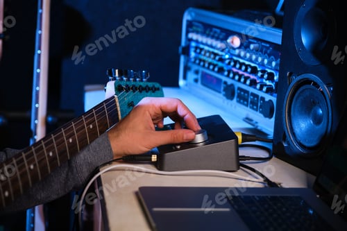 Preview: Close up of musician hand adjusting the sound of his guitar with equalizer.