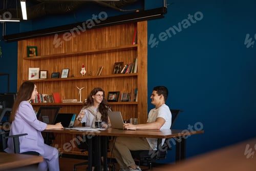 Preview: Young professionals gathered at large table to discuss the project