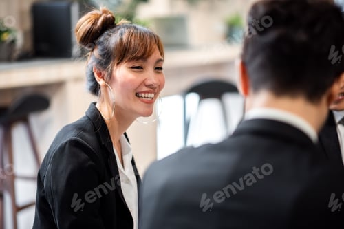 Preview: Smiling asian business woman while working with colleague in office