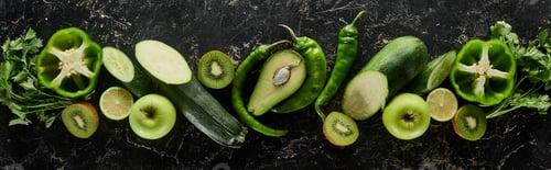 Preview: panoramic shot of fresh apples, limes, peppers, cucumbers, avocado, greenery, kiwi and zucchini