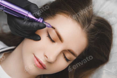 Preview: A cosmetologist applies permanent makeup to the eyebrows - eyebrow tattoo. eyebrow perm