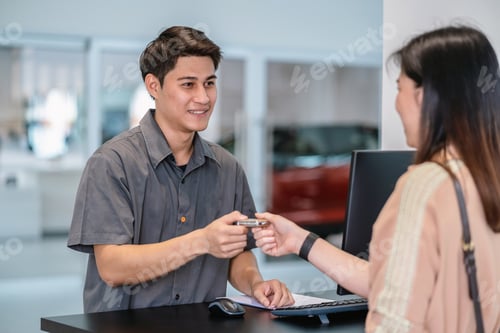 Preview: Asian mechanic recieving the automatic car key for checking at maintainance service center