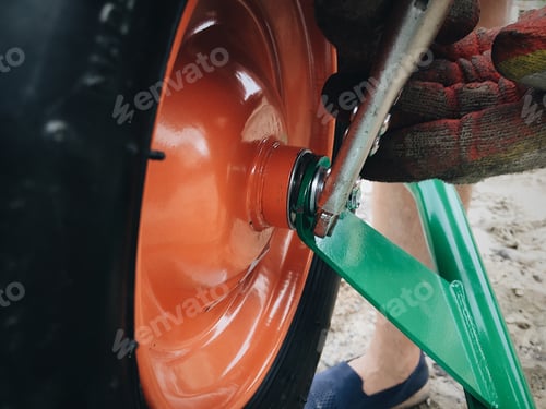 Assembling Garden Wheelbarrow with Spanner and Gloved Hands
