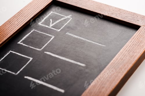 Preview: close up of chalk board with tick in checklist isolated on white