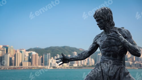 Preview: Bruce Lee statue stands proudly on the Hong Kong waterfront against a backdrop of the city skyline