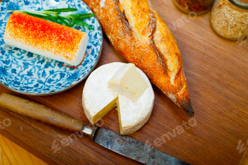 Preview: French cheese and fresh baguette on a wood cutter