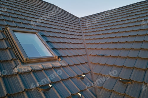 Preview: Closeup of attic window on house roof top covered with ceramic shingles. Tiled covering of building