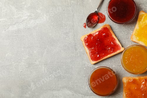 Preview: Bowls and toasts with jam on gray background, top view