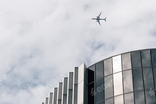 Preview: Plane over skyscrapers in the city of London. Low angle view against cloudy sky