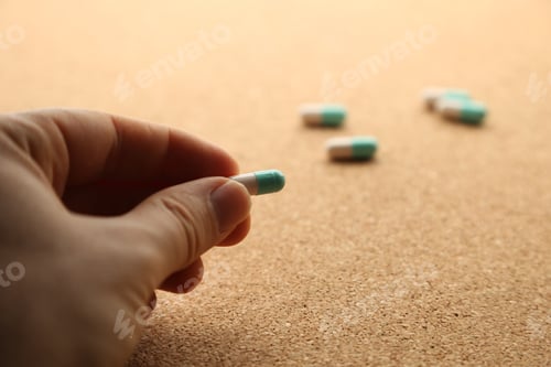 Preview: Selective focus shot of a woman's hand holding a medicine