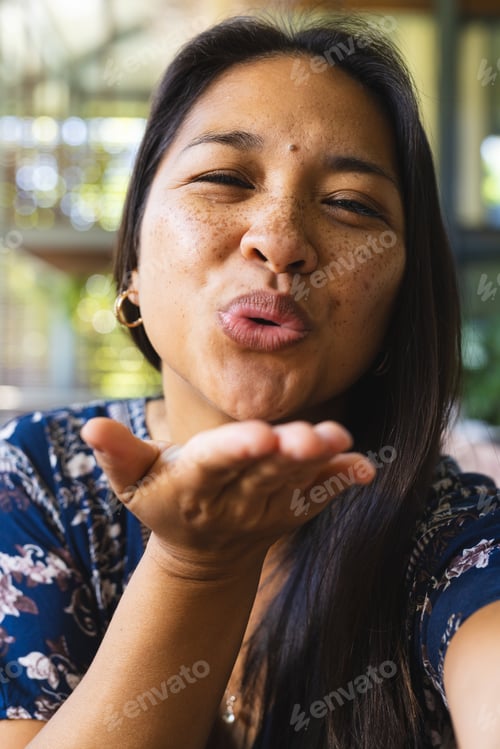 Preview: Portrait of happy asian woman with long hair kissing and having video call at home