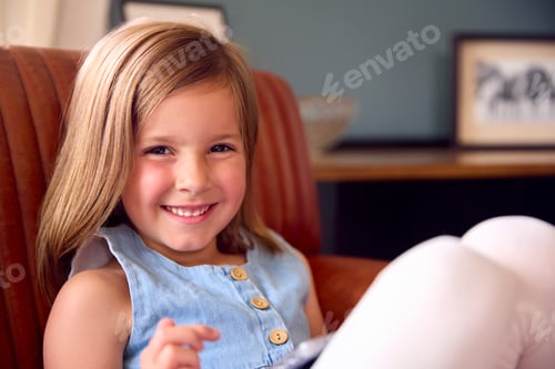 Preview: Portrait Of Smiling Young Girl At Home Sitting On Chair