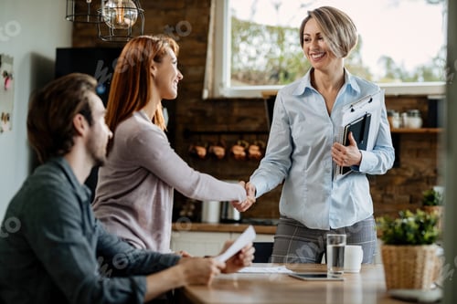 Preview: Happy real estate agent shaking hands with a couple after the meeting.
