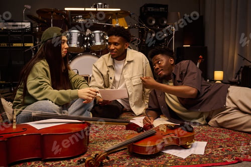 Preview: Young Multiethnic Musicians Discussing Sheet Music While Sitting on Studio Floor