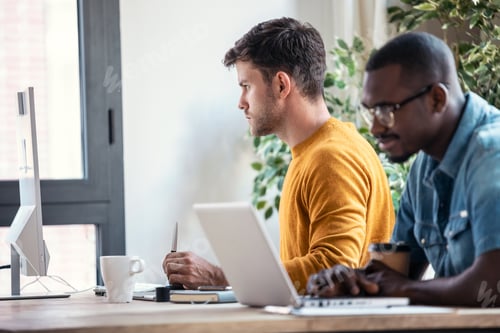 Preview: Two concentrated graphic designer working with computer in modern startup office.