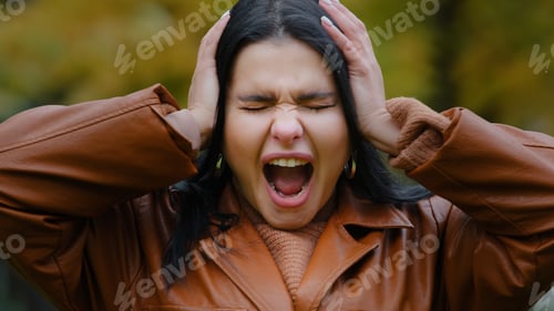 Preview: Portrait annoyed young hispanic woman outdoors screaming loudly in rage madly opening mouth holding
